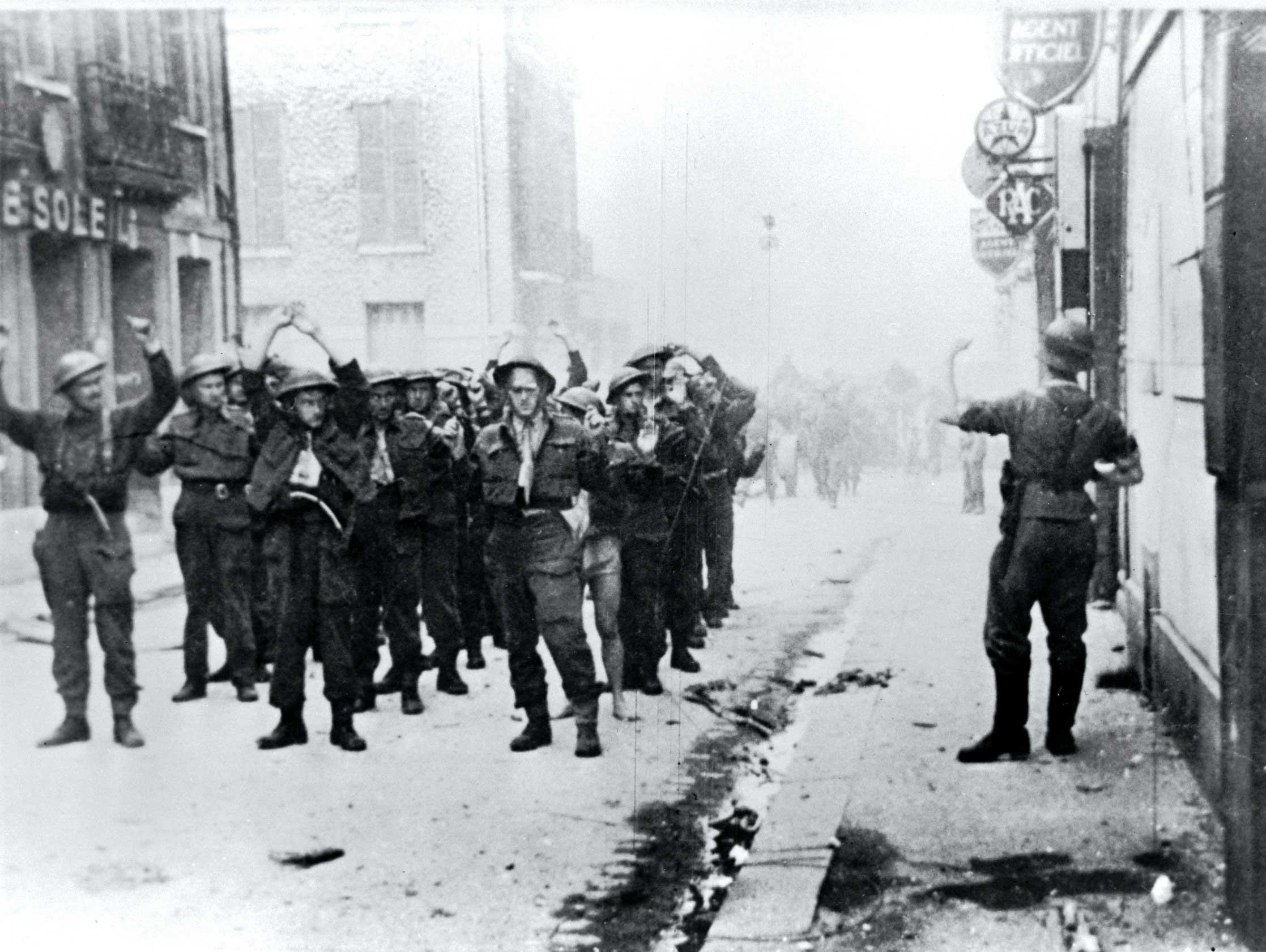 
 A german soldier directs Canadian prisoners of war through Dieppe after the disasterous raid. 