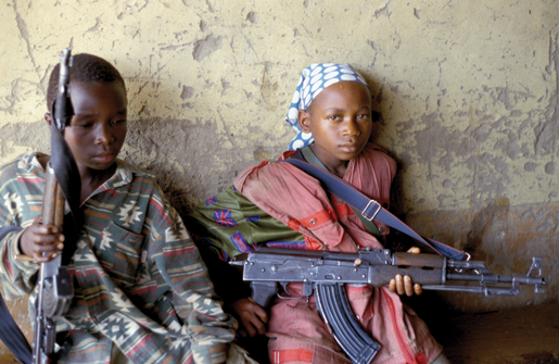 Un magasin pillé en République démocratique du Congo sert de poste de commandement à des enfants soldats en 2003. La fille à droite est de faction. [PHOTO : ROGER LEMOYNE, ACDI]