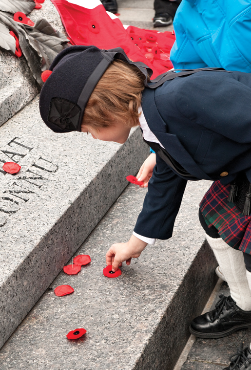Des enfants déposent leur coquelicot sur la Tombe. [PHOTO : METROPOLIS STUDIO]