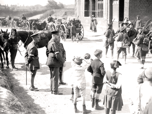 Le général sir Arthur Currie et quelques enfants regardent des soldats canadiens défiler vers un camp de repos après le combat à la côte 70. [PHOTO : BIBLIOTHÈQUE ET ARCHIVES CANADA—PA001826]
