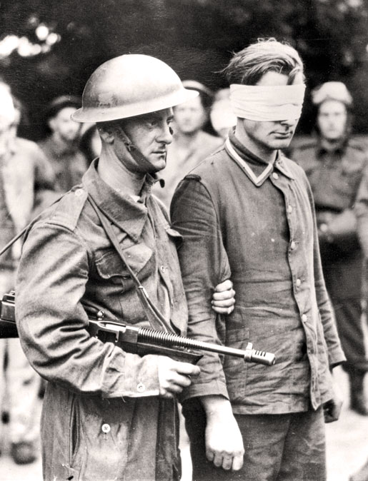 Un Canadien escorte un Allemand capturé pendant le raid. [PHOTO : BIBLIOTHÈQUE ET ARCHIVES CANADA—PA210156]