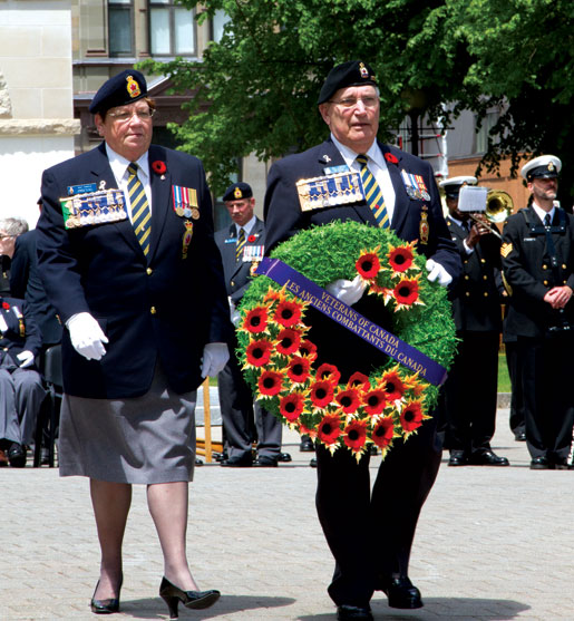 La présidente Pat Varga, accompagnée par le président sortant Wilf Edmond, dépose une couronne. [PHOTO : DAN BLACK]