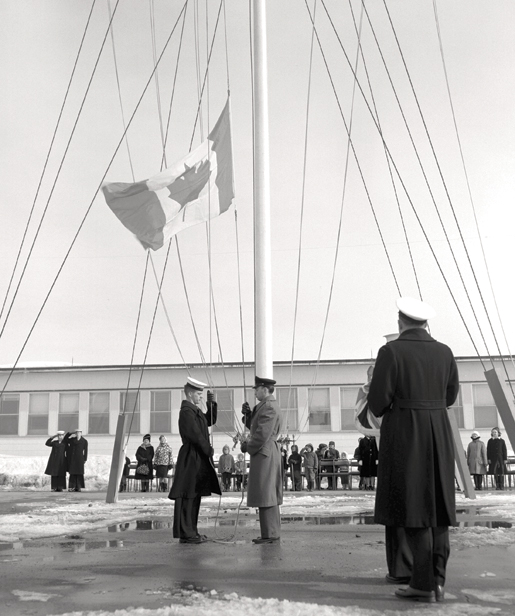 Le nouveau drapeau canadien est hissé en 1965 à un établissement de la marine. Pendant la même décennie, il y a eu l’unification des forces, ce qui a mené à un uniforme commun et à une structure de grades commune. [PHOTO : MINISTÈRE DE LA DÉFENSE NATIONALE]