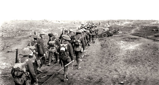Des soldats canadiens, certains d’entre eux portant une pioche ou une pelle, suivent une voie ferrée à la Somme, en septembre 1916. [PHOTO : MINISTÈRE DE LA DÉFENSE NAITONALE/BIBLIOTHÈQUE ET ARCHIVES CANADA—PA000682]