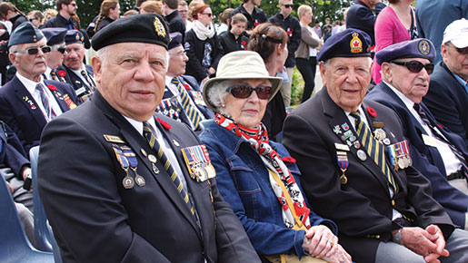 Les anciens combattants Pierre Bruneau (à g.) et Benoît Gauthier (troisième à g.) assistent à la cérémonie au cimetière militaire canadien de Bretteville-sur-Laize. [PHOTO : SHARON ADAMS]