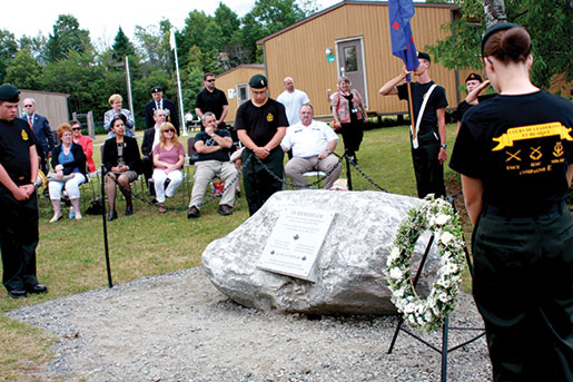 Des couronnes sont déposées près d’une roche commémorative sur laquelle une plaque porte les noms des cadets morts lors de l’explosion de 1974. [PHOTO : Sharon Adams]