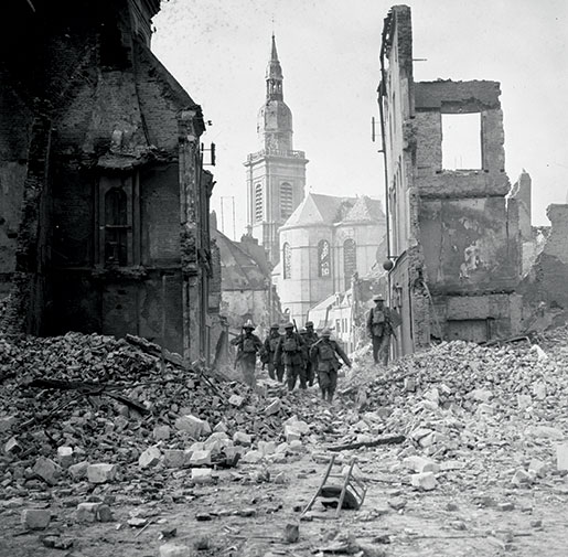 Des soldats canadiens se fraient un chemin à travers les rues pleines de débris de Cambrai, en France, en octobre 1918. [PHOTO : MINISTÈRE DE LA DÉFENSE NATIONALE, BIBLIOTHÈQUE ET ARCHIVES CANADA—PA003286]