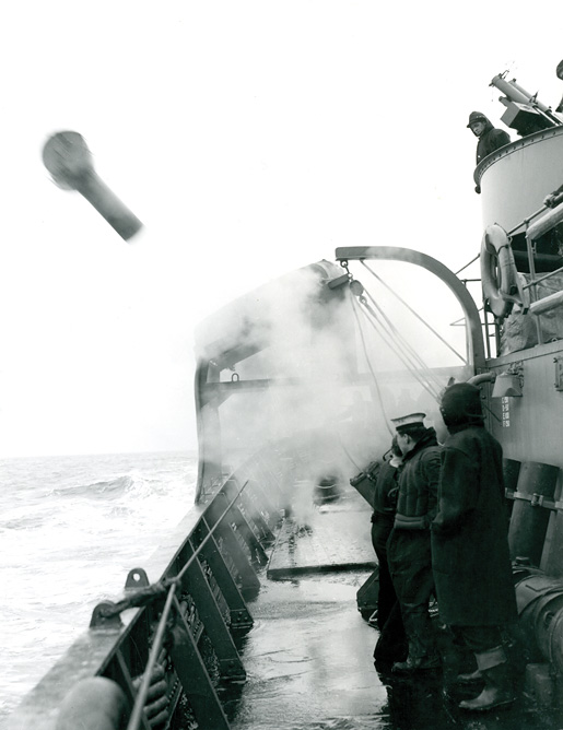 A depth charge and its carrier leave HMCS Pictou. [PHOTO: LIBRARY AND ARCHIVES CANADA—PA116838]