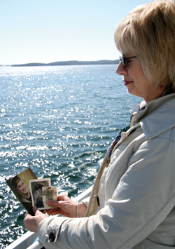 Susan Clark looks at photos of her father while on board HMCS Sackville. Her father’s ashes were later committed to the sea. [PHOTO: DAN BLACK]