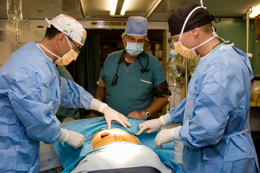 Canadian and Dutch surgeons prepare a patient for abdominal surgery. [SGT. GERBEN VAN ES, TASK FORCE AFGHANISTAN ROTO 1]