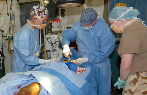 Dr. Vivian McAlister (centre) sutures a head wound, aided by Dutch colleagues. [PHOTO: MASTER CPL. KEVIN PAUL]