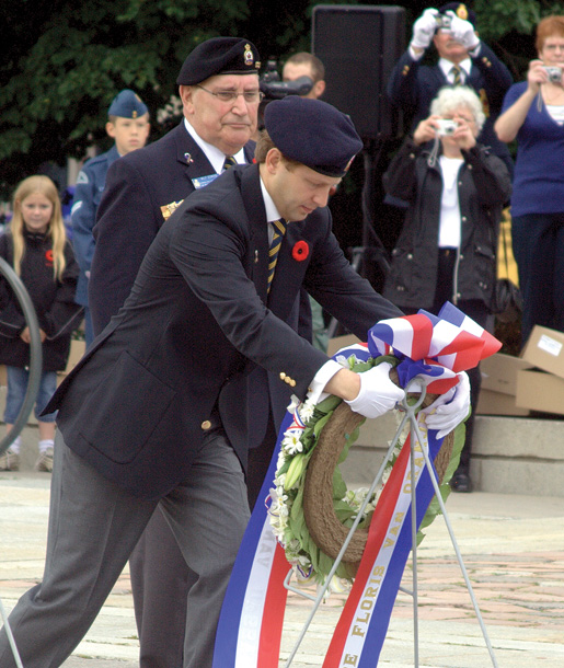 The prince, assisted by First Vice Wilf Edmond, places a wreath. [PHOTO: ADAM DAY]