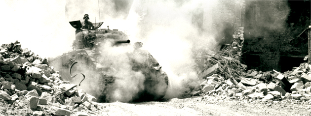 A tank rumbles through San Pancrazio, Italy, July 1944. [PHOTO: ALEX STIRTON, LIBRARY AND ARCHIVES CANADA—PA115031]