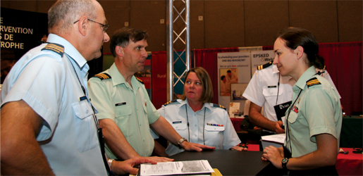 From left: Maj. Alain Gagnon, Lt.-Col. Randy Russell, Capt. Anne Johnston and Maj. Annette Snow participate in a planning session in the Canadian Forces recruitment booth at an emergency physicians’ convention. [PHOTO: SHARON ADAMS]