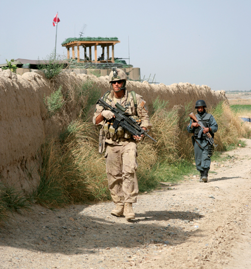 A Bravo Company soldier and an Afghan policeman leave Haji for a patrol. [PHOTO: ADAM DAY]