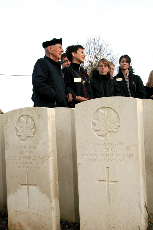 Veterans and youth inspect headstones. [PHOTO: SHARON ADAMS]