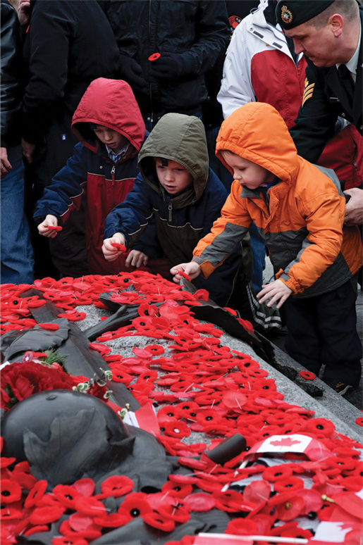 Children place their poppies on the Tomb of the Unknown Soldier. [PHOTO: METROPOLIS STUDIO]