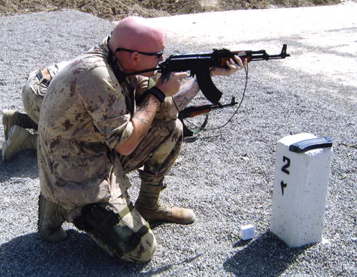 Doyle test fires an AK-47 in Kabul in 2004. [PHOTO: COURTESY NICOLE DOYLE]
