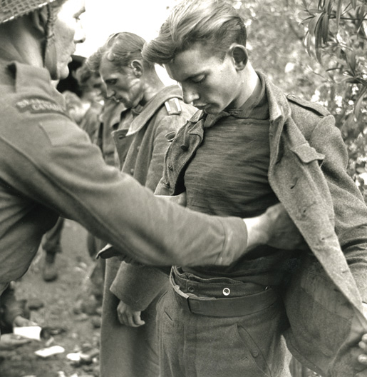 A Canadian soldier searches a young German soldier captured Dec. 9, 1943. [PHOTO: TERRY ROWE, LIBRARY AND ARCHIVES CANADA–PA114485]