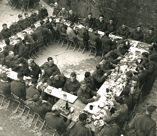 Members of the Seaforth Highlanders sit down for their Christmas dinner. [PHOTO: TERRY ROWE, LIBRARY AND ARCHIVES CANADA–PA152839]