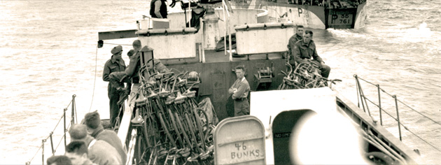 Landing craft en route to Normandy, June 6, 1944. Note the stack of bicycles and the number on the door telling how many bunks are below. [PHOTO: GILBERT ALEXANDER MILNE, LIBRARY AND ARCHIVES CANADA–PA135966]