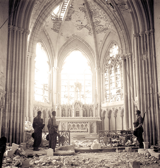 Unidentified Canadian infantry visit a bomb-damaged church in Carpiquet, near Caen, July 12, 1944. [PHOTO: KEN BELL, LIBRARY AND ARCHIVES CANADA–PA162545]