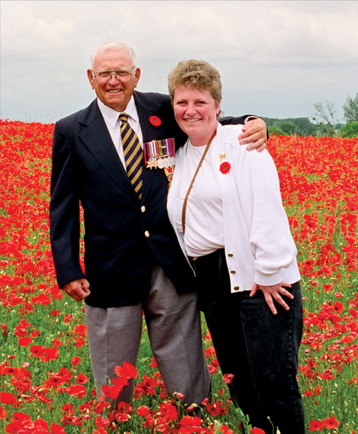 Second World War veteran Fred Budge and Cynthia Dufault are surrounded by poppies near St. Lambert-sur-Dives during the 1996 Dominion Command Youth Leaders’ Pilgrimage of Remembrance. [PHOTO: DAN BLACK]