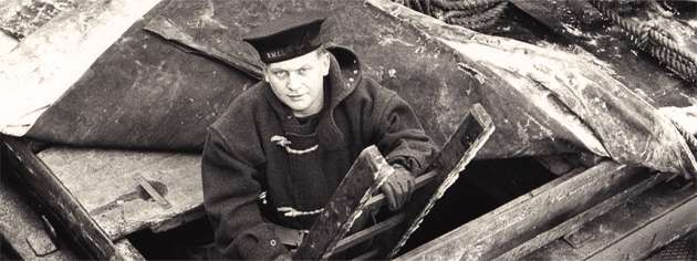 A member of the RCN Naval Control of Shipping Service emerges from a ship’s hold after examining the cargo. [PHOTO: LIBRARY AND ARCHIVES CANADA—PA104427]
