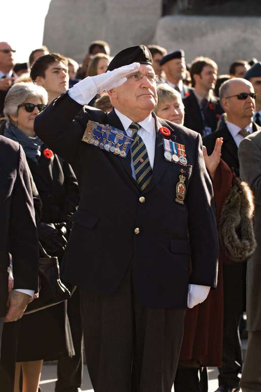 Legion Dominion President Wilf Edmond salutes during the ceremony. [PHOTO: METROPOLIS STUDIO]