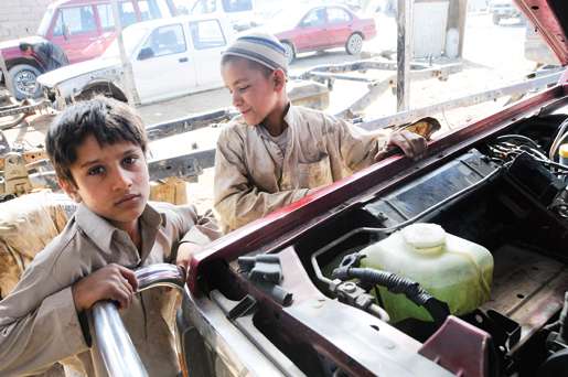 Children work in an auto shop at a trading  bazaar. Child labour is common in Afghanistan, as many families struggle to put food on the table. [PHOTO: MATTHIEU AIKINS]