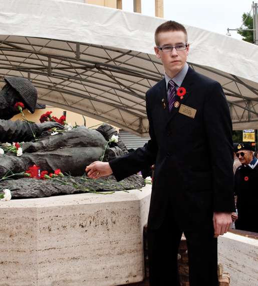 Youth representative Nolan Hill stands by the Price of Peace Monument. [PHOTO: TOM MacGREGOR]