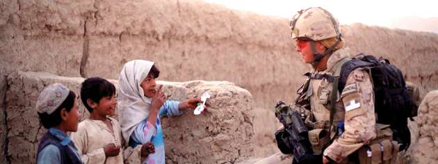 Cpl. Becky Hudson with some little residents of Salavat. [PHOTO: ADAM DAY]