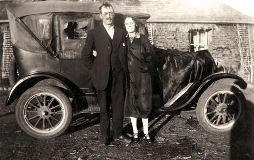 James Addison and his wife in front of car and home. [PHOTO: COURTESY LENORE McTAGGART]