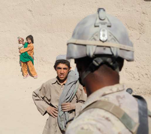 A young Afghan and a Canadian soldier appraise each other. [PHOTO: ADAM DAY]