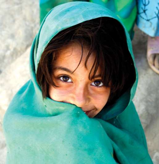 An Afghan girl smiles after receiving some Canadian candy. [PHOTO: ADAM DAY]