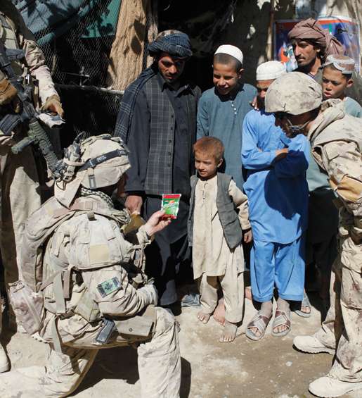 Sergeant Dwayne MacDougall speaking to children outside an Afghan shop. [PHOTO: ADAM DAY]