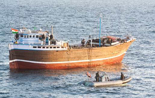 The ship’s Rigid-hulled Inflatable Boat waits near a dhow as members of the boarding party conduct an inspection. [PHOTO: DAN BLACK]