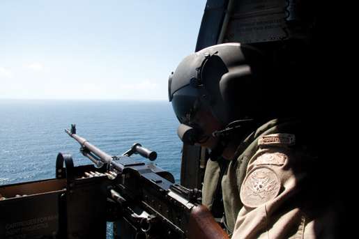 The Sea King’s machine-gun is manned during a patrol. [PHOTO: DAN BLACK]