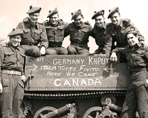 Smiles and a sign say it all following the end of hostilities in Europe. [PHOTO: LEGION MAGAZINE ARCHIVES]