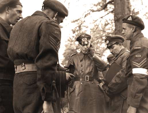 A German officer is linked up with Canadian and  German forces at Wageningen in the Netherlands. [PHOTO: ALEXANDER STIRTON, LIBRARY AND ARCHIVES CANADA—PA138588]