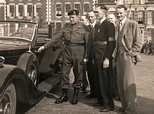 Dutch Resistance members and Canadian Maj.-Gen. B.M. Hoffmeister examine a captured German car, May 11, 1945. [PHOTO: G. FLEMING, LIBRARY AND ARCHIVES CANADA—PA138055]