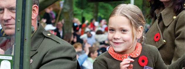 A young girl has a soldier’s photo pinned to her sweater during the Apeldoorn liberation parade. [PHOTO: TOM MacGREGOR]