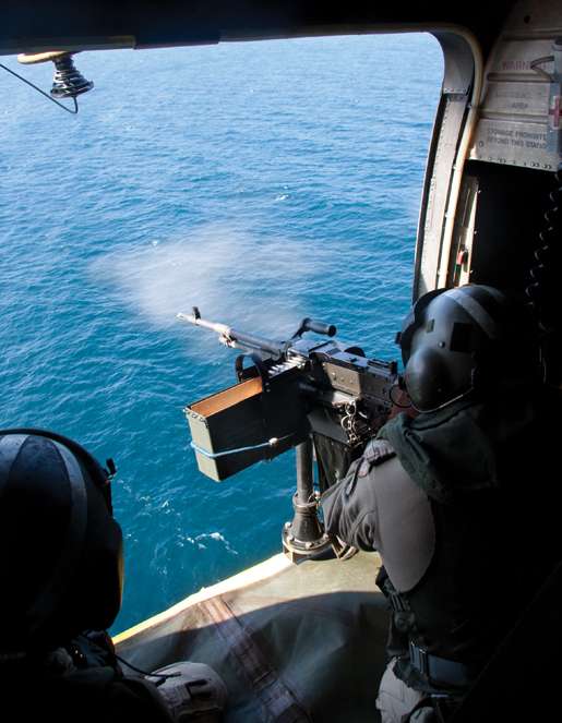 A crew member participates in a proficiency gun shoot,  firing the mounted C-6 machine-gun at a target below. [PHOTO: DAN BLACK]