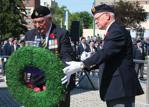 Dominion President Wilf Edmond (left) places a wreath with assistance from Past President Jack Frost. [PHOTO: JENNIFER MORSE]