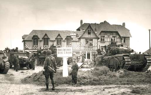 Canadian troops on the outskirts of St. Aubin-sur-Mer on D-Day. [PHOTO:  FRANK L. DUBERVILL, LIBRARY AND ARCHIVES CANADA—PA128789]