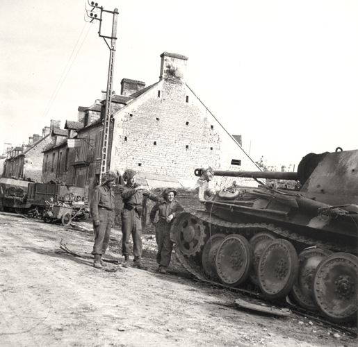 Members of the Regina Rifles examine a destroyed enemy tank, June 8, 1944. [PHOTO: DONALD I. GRANT, LIBRARY AND ARCHIVES CANADA—PA116529]