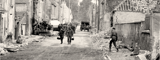 Canadian soldiers move into Bretteville, France, June 20, 1944. [PHOTO: FRANK L. DUBERVILL, LIBRARY AND ARCHIVES CANADA—PA133732]