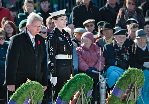 VAC Minister Jean-Pierre Blackburn, aided by cadet Nadine Kelly, pays his respects to the fallen. [PHOTO: METROPOLIS STUDIO]