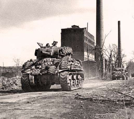 Tanks of the Sherbrooke Fusiliers move up to assist the infantry in clearing a  German town, March 1945. [PHOTO: ERNEST J. DeGUIRE, LIBRARY AND ARCHIVES CANADA—PA192258]
