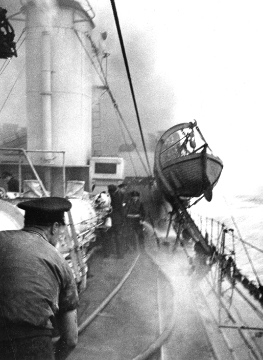 Sailors fight to control a fire on HMCS Assiniboine during the action which resulted in the sinking of U-210. [PHOTO: LIBRARY AND ARCHIVES CANADA—PA184007]